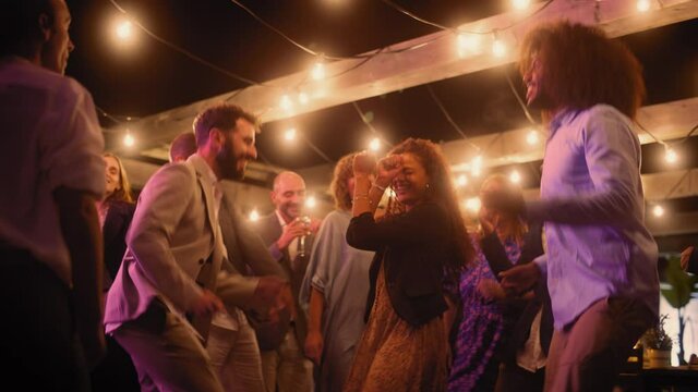Beautiful Carefree Friends are Dancing Together and Celebrating an Evening Event at a Party. Diverse Multiethnic Young Adult People Have Fun at a Corporate Party in a Restaurant.