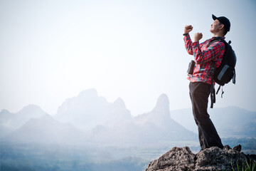 Success man hiker outstretched arms stand at cliff edge on mountain top.Concept of adventure travel