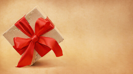Cardboard carved gift box with a red bow on a light background