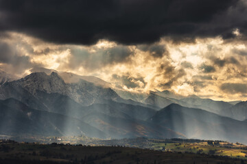 Tatra Mountains seen on a cloudy day. The shining light between the clouds creates an interesting atmosphere in the photo.