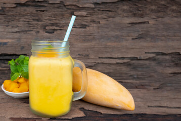 Mango juice fruit smoothies yogurt drink yellow healthy delicious taste in a glass slush for weight loss on wooden background.