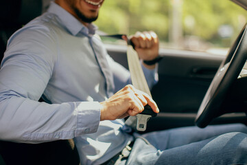 Cropped of arab guy fastening seatbelt, safety driving concept
