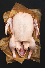 Raw whole duck. Ready to bake. Black table background. Top view