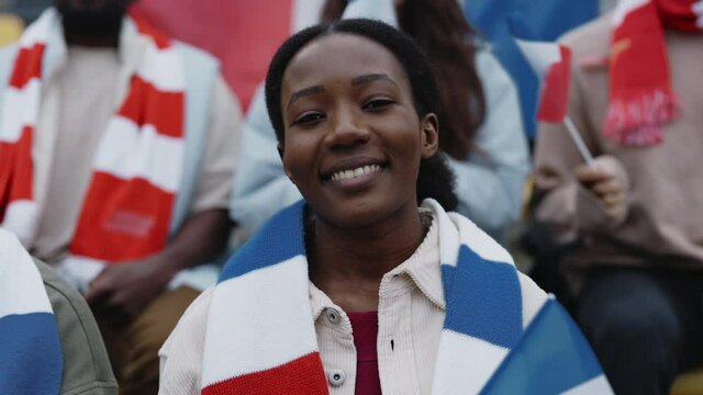 African american woman watching soccer game on stadium