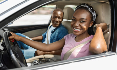 Cheerful african american couple having car trip together