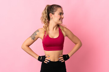 Fototapeta na wymiar Young Brazilian woman isolated on pink background posing with arms at hip and looking side