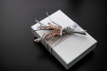 A white wrapped gift box on a black background 