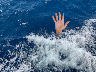 A drowning man asks for help. The hand of a man in the deep sea. Sticking your hand out of the sea...
