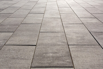 Paving with large long concrete slabs. Symmetrical decreasing perspective. Selective focusing.