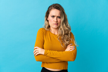 Young Brazilian woman isolated on blue background with unhappy expression