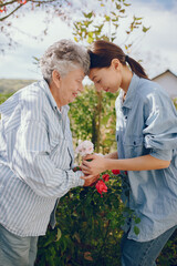 Old woman in a garden with young granddaughter