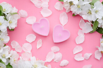 Spa treatments as a gift for Valentines Day, banner - with candles in the form of hearts with petals on a pink background