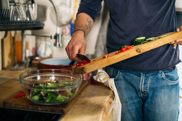 man preparing salad in his kitchen