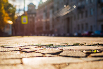 Sunny autumn day. A row of parked cars on the street. The pavement after the rain. Focus on the manhole cover. Close up view of a manhole cover at the level of the pavement.