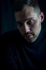 portrait of a young man in a black turtleneck with an intense and captivating look