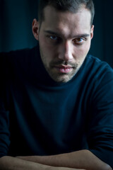 Fototapeta premium portrait of a young man in a black turtleneck with an intense and captivating look