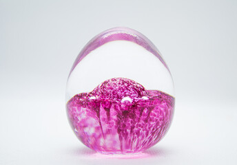 Pink colored glass ball on white background