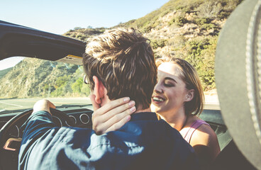 Couple driving on a convertible car on a coast to coast travel in California