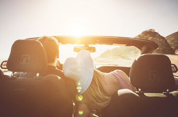 Couple driving on a convertible car on a coast to coast travel in California - obrazy, fototapety, plakaty
