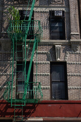 Exterior of a Beautiful Old Apartment Building on the Lower East Side of New York City with a Green Fire Escape and Ladder