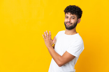 Young Moroccan man isolated on yellow background scheming something