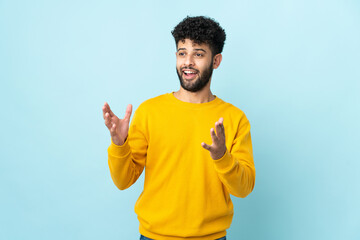 Young Moroccan man isolated on blue background with surprise facial expression - obrazy, fototapety, plakaty