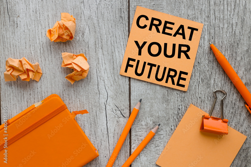 Poster create your future. text on orange sticky paper on a gray background