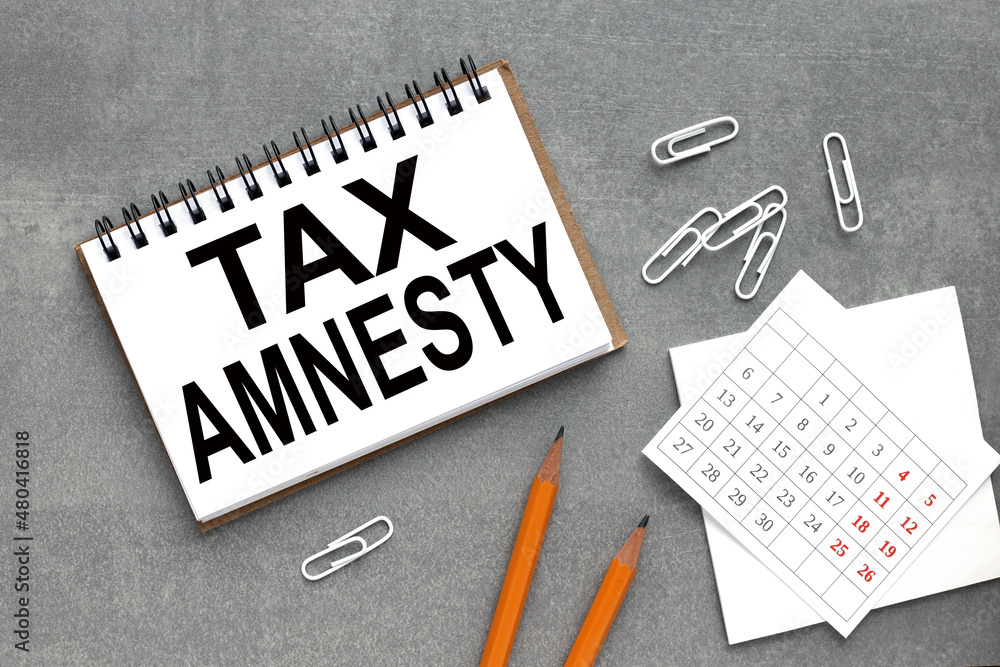 Poster tax amnesty text on open notepad with calendar