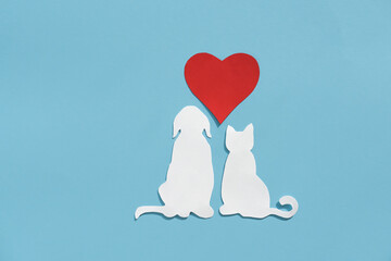 Paper silhouette of a cat, dog and red heart on a blue background. Flat lay, place for text....