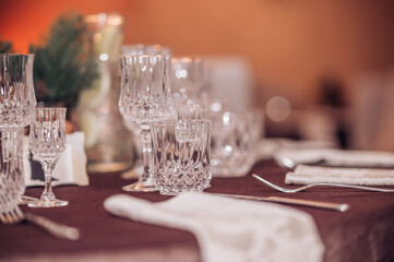 Empty crystal glasses on house dinner table. Restaurant, banquet setting with crystal glasses
