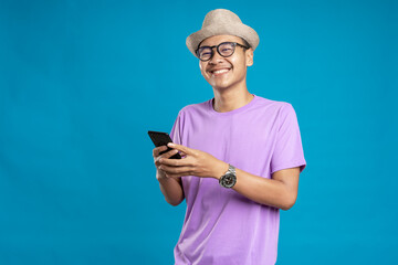 Smart casual asian man using smartphone in studio background