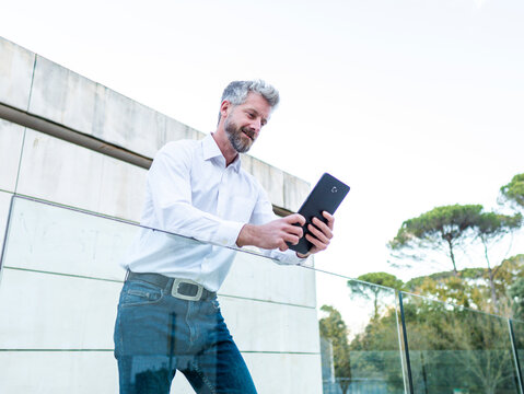 Man browsing tablet near fence