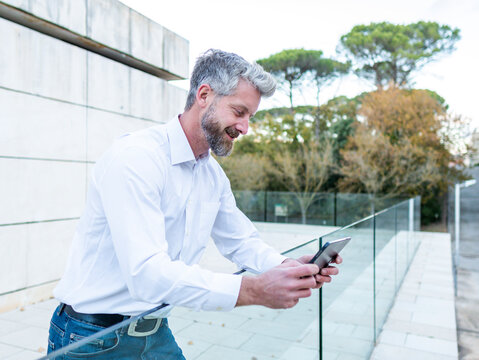 Man browsing tablet near fence