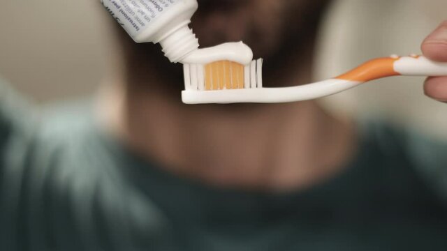 Man hand holding toothbrush and tooth paste tube, then brush his teeth