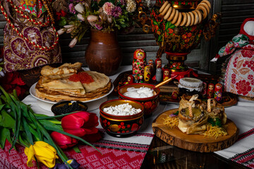pancakes on a white plate. on the pancakes - a piece of butter. black sturgeon and red salmon caviar are served with pancakes on Shrovetide