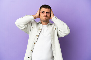 Brazilian man over isolated purple background frustrated and covering ears