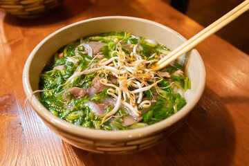 Traditional Vietnamese noodle soup in a plate on the table in a restaurant