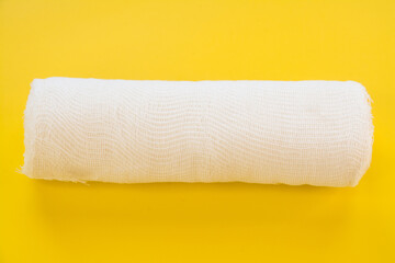White medical bandage on yellow background top view