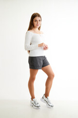 Beautiful young woman or girl wearing casual clothes on white background. Young female model posing during photo shoot