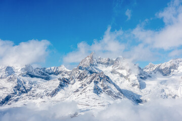 Fototapeta na wymiar Snow-capped mountains against the blue sky