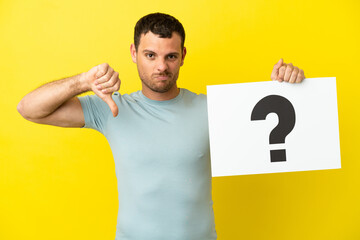 Brazilian man over isolated purple background holding a placard with question mark symbol and doing...