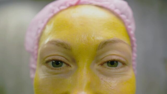 Procedure for skin care to face of young pretty woman. Beauty salon, facial peeling yellow gold alginate mask with retinol treatment, fruit acids.