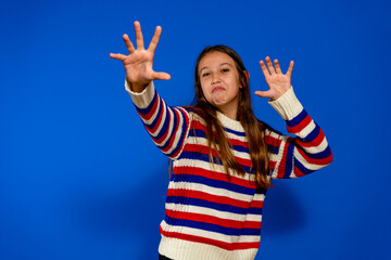 Photo of funny funky preteen girl hands claws roaring wearing a striped sweater isolated aquamarine background.