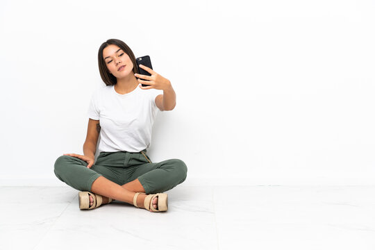 Teenager girl sitting on the floor making a selfie