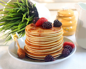 Pancakes on a plate with berry syrup.