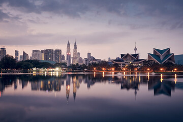 Fototapeta na wymiar Urban skyline of Kuala Lumpur at dawn. Reflection of skyscrapers in the water surface.