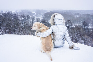 Girl with a white dog in the snow in winter