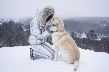 Girl with a white dog in the snow in winter