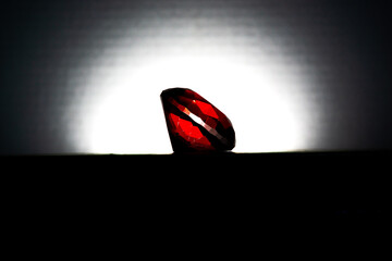 small red gem being illuminated in the dark
