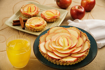 mesa com tortas de maçã e copo de vidro com suco natural